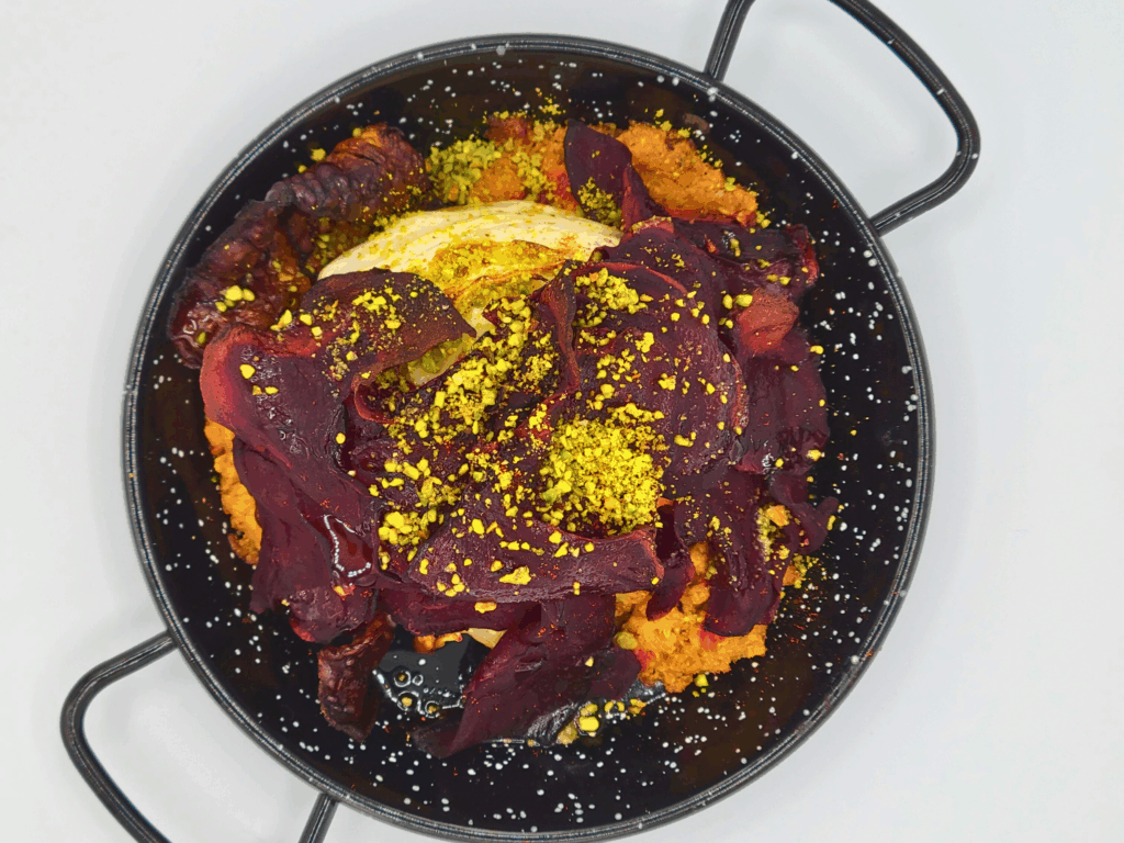 a piece of cabbage braised in a small paella pan